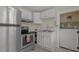 A cozy kitchen featuring stainless steel appliances, white cabinets, and double basin sink at 509 E Ashley Ave, Folly Beach, SC 29439