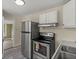 A cozy kitchen with stainless steel appliances, white cabinets, and vinyl flooring at 509 E Ashley Ave, Folly Beach, SC 29439