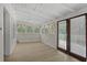 A sunny sunroom with beamed ceilings, lots of windows, neutral flooring, and double doors at 509 E Ashley Ave, Folly Beach, SC 29439