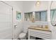 Bright bathroom featuring a granite countertop vanity, toilet, and beadboard paneling at 509 W Ashley Ave, Folly Beach, SC 29439