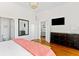 Bedroom featuring hardwood floors, large television, and ensuite bathroom access at 509 W Ashley Ave, Folly Beach, SC 29439