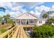 Charming pink beach house with a wooden walkway leading to the entrance, nestled among lush greenery at 509 W Ashley Ave, Folly Beach, SC 29439