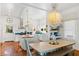 Bright, modern kitchen with stainless steel appliances, an island, and a chandelier above the dining table at 509 W Ashley Ave, Folly Beach, SC 29439