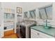 Well-lit laundry area with modern machines, adjacent to a sink and vanity with views into the bathroom at 509 W Ashley Ave, Folly Beach, SC 29439