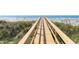Wooden walkway leading to the sandy beach and ocean with grasses on either side at 509 W Ashley Ave, Folly Beach, SC 29439