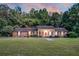 Expansive view of a single-story brick home featuring a large front lawn and mature trees at 598 Maple Branch Rd, Reevesville, SC 29471
