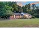 A brick home boasts a wide lawn, mature trees, and driveway at 598 Maple Branch Rd, Reevesville, SC 29471