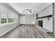 Bright living room featuring a brick fireplace, large window, and hardwood floors at 598 Maple Branch Rd, Reevesville, SC 29471