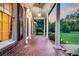 Covered porch features brick floors, white pillars, and an outdoor lighting fixture at 598 Maple Branch Rd, Reevesville, SC 29471