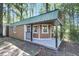 Exterior angle of a newly constructed shed featuring a front porch with black railings and an attached garage door at 598 Maple Branch Rd, Reevesville, SC 29471