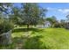 Lush backyard with a mature tree, residential house, and a well-maintained green lawn under a bright blue sky at 604 Longstreet St, Summerville, SC 29486