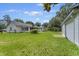 Expansive backyard featuring a garage and a screened-in sunroom attached to the house, surrounded by trees at 604 Longstreet St, Summerville, SC 29486
