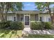 Charming home exterior featuring a screened-in front porch, lush bushes, and a neatly maintained lawn at 604 Longstreet St, Summerville, SC 29486