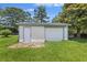 Exterior shot of a detached single car garage with a side door, situated on a green lawn with trees at 604 Longstreet St, Summerville, SC 29486
