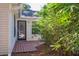 Inviting back porch with a dark door and wood floors, surrounded by lush bamboo, creating a private outdoor space at 642 Bridlewood Ln, Mount Pleasant, SC 29464