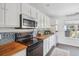 Modern kitchen with black appliances, butcher block countertops, mosaic tile backsplash, and ample storage at 642 Bridlewood Ln, Mount Pleasant, SC 29464