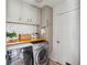Well-organized laundry room with white cabinets, butcher block countertop, subway tile and stainless steel appliances at 642 Bridlewood Ln, Mount Pleasant, SC 29464