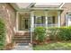 Close up front porch with brick stairs, decorative columns, trimmed shrubbery and welcoming entryway at 652 Spinner Cir, Mount Pleasant, SC 29464