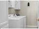 Bright laundry room with modern white appliances, cabinets and gray tiled floors at 652 Spinner Cir, Mount Pleasant, SC 29464