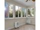 Bright sunroom with tiled floors, large windows showcasing green trees, and a dehumidifier at 652 Spinner Cir, Mount Pleasant, SC 29464