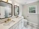 Bathroom featuring double sinks, modern fixtures, marble countertops, and a glass-enclosed shower at 702 Spark St, Mount Pleasant, SC 29464