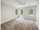 Large bedroom with neutral walls, three windows for natural light, and a ceiling fan at 702 Spark St, Mount Pleasant, SC 29464