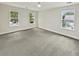 Neutral bedroom with gray carpet, white walls, three windows, and bright natural light at 702 Spark St, Mount Pleasant, SC 29464