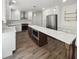 Open kitchen with white cabinets, stainless steel appliances, and a large island with countertop seating at 702 Spark St, Mount Pleasant, SC 29464