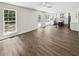 Open living space with hardwood floors, white walls, bright windows, and an open kitchen at 702 Spark St, Mount Pleasant, SC 29464