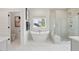 Bright bathroom featuring a modern soaking tub, glass enclosed shower, and white tile floors at 766 Maynard Ln, Summerville, SC 29486