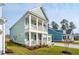 Beautiful two-story home showcases light blue siding, a covered front porch, and a lovely landscaped yard at 766 Maynard Ln, Summerville, SC 29486