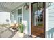 Inviting front entrance with a wood door, classic lanterns, and a cozy bench with a potted plant at 766 Maynard Ln, Summerville, SC 29486