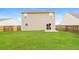 Expansive backyard with lush green grass, a fenced perimeter, and a sliding glass door at 8285 Little Sydneys Way, North Charleston, SC 29406