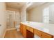Bright bathroom with a glass-enclosed shower, wood cabinets, and large vanity mirror at 8285 Little Sydneys Way, North Charleston, SC 29406