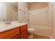 Well-lit bathroom features a tub with shower, vanity with sink, and wood-grain cabinets at 8285 Little Sydneys Way, North Charleston, SC 29406