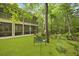 Lush backyard showcasing a screened porch, a metal bench, and vibrant greenery, ideal for relaxation and entertainment at 8400 Camp Gregg Ln, North Charleston, SC 29418
