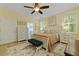Bright bedroom with hardwood floors and ceiling fan, featuring a view to an ensuite bathroom at 8400 Camp Gregg Ln, North Charleston, SC 29418
