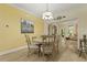 Bright dining room with wood floors, a modern chandelier, and views into the living room at 8400 Camp Gregg Ln, North Charleston, SC 29418