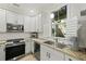 Well-lit kitchen featuring white cabinets, stainless steel appliances, and beautiful granite countertops at 8400 Camp Gregg Ln, North Charleston, SC 29418