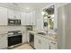 Well-lit kitchen featuring white cabinets, stainless steel appliances, and beautiful granite countertops at 8400 Camp Gregg Ln, North Charleston, SC 29418