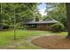 Expansive green backyard with large trees and a traditional brick home at 96 King Charles Cir, Summerville, SC 29485