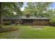 Spacious backyard with mature trees, lawn, patio, and traditional brick home at 96 King Charles Cir, Summerville, SC 29485