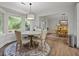 Cozy dining area features a decorative light fixture, four chairs, and a large sunny window at 96 King Charles Cir, Summerville, SC 29485