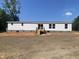 The back of the manufactured home has a wooden porch, windows, and sliding door at 1010 Universal Cir, Saint Stephen, SC 29479