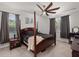 Spacious bedroom featuring a four-poster bed, two windows, ceiling fan, and neutral carpeting at 106 Claremont Ct, Summerville, SC 29486