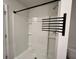 Modern all-white shower with black hardware, including a shower head and towel rack at 109 Rosefield Ct, Summerville, SC 29485