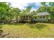 Spacious backyard featuring a well-manicured lawn, mature trees, and a screened porch, perfect for outdoor living at 1098 Blue Marlin Dr, Charleston, SC 29412