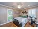 Bedroom with a stationary bike, ceiling fan, plantation shutters, and hardwood floors at 1098 Blue Marlin Dr, Charleston, SC 29412
