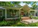 Charming home boasts a cozy porch with swing, complemented by a bright red door and lush landscaping at 1098 Blue Marlin Dr, Charleston, SC 29412