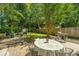 Inviting patio with an outdoor dining area, grill, and view of the lush backyard and cozy fire pit at 1098 Blue Marlin Dr, Charleston, SC 29412